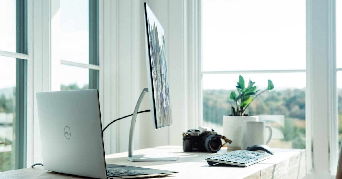 Clean dedicated home office workspace with laptop and desk