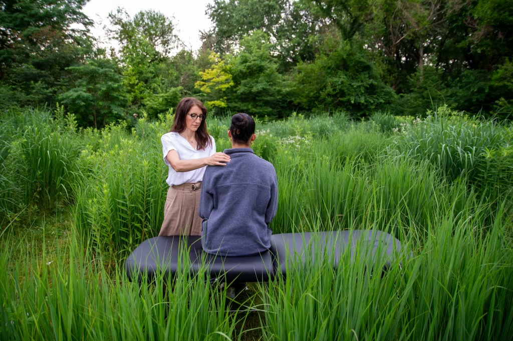 Dr. Erin Burns performing a seated osteopathic manual therapy technique on a patient