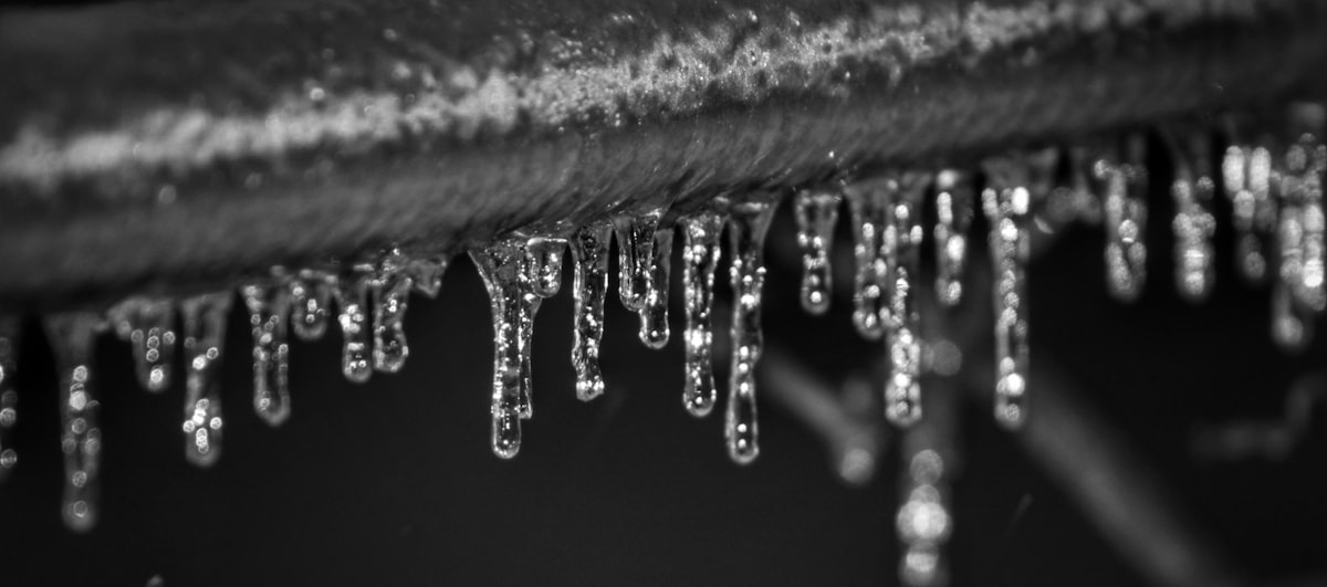 Icicles forming on a frozen pipe in winter