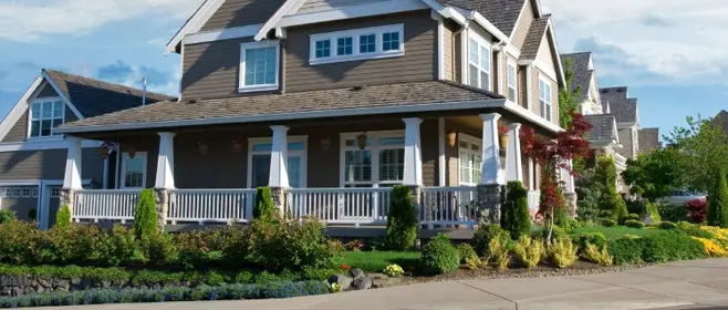 Craftsman home with a freshly manicured front-yard landscape and trimmed shrubs