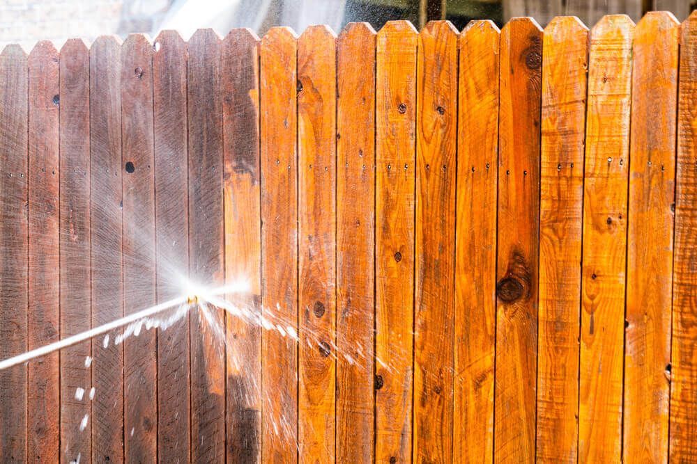 Pressure washing a wood fence