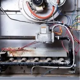 Gas furnace with its access panel removed, ready for a technician inspection